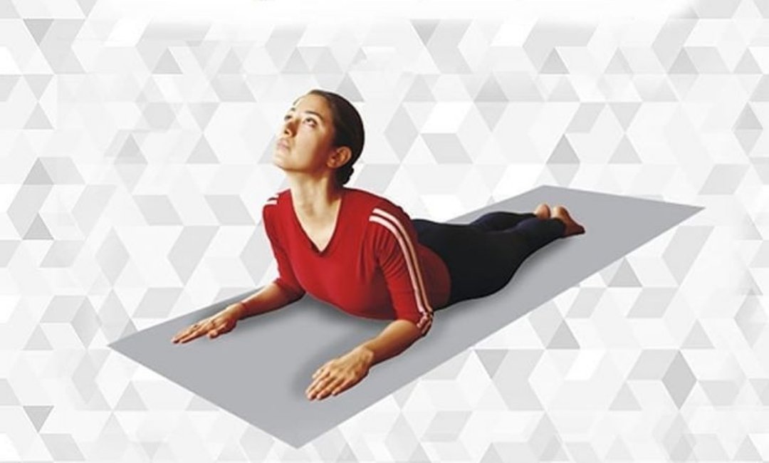 Person practicing Bhujangasana with chest lifted and palms beside the chest