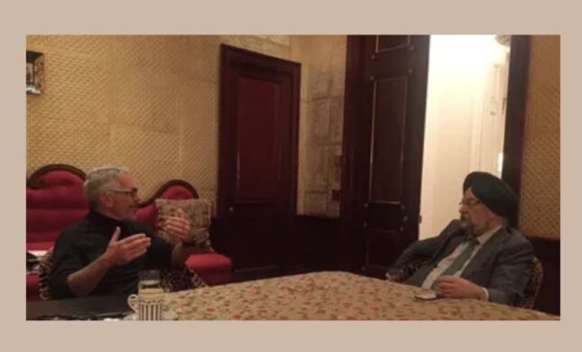 Hardeep Singh Puri seated across a table from Jeffrey Epstein