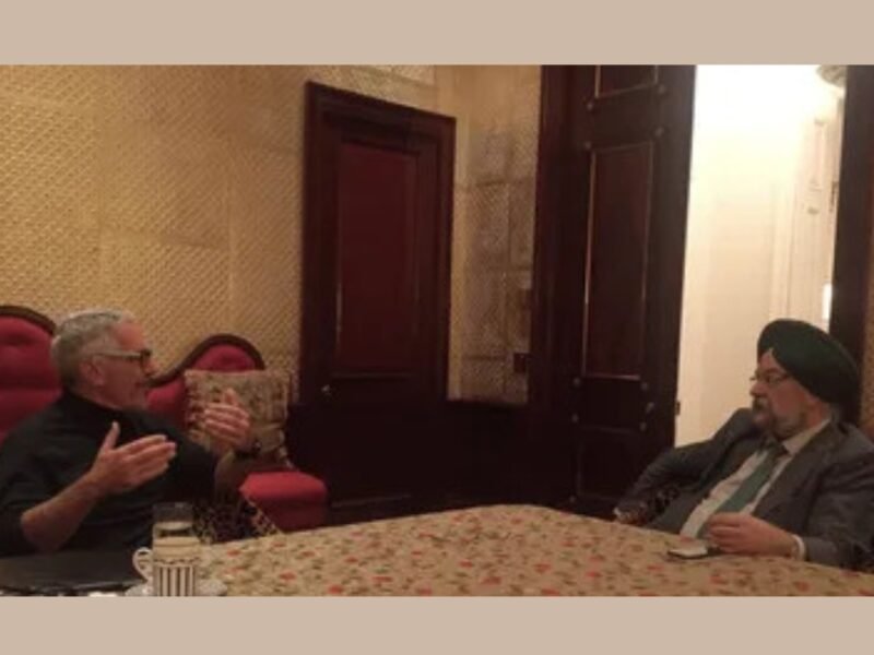 Hardeep Singh Puri seated across a table from Jeffrey Epstein