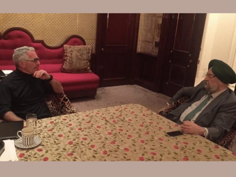 Hardeep Singh Puri seated across a table from Jeffrey Epstein