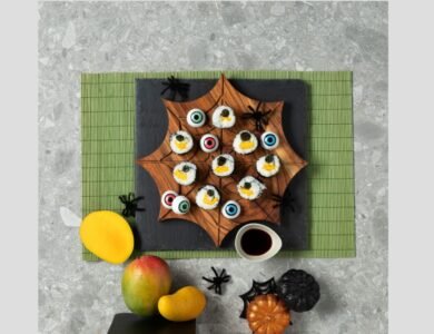 Mango sushi rolls arranged like a caterpillar with nori eyes for Halloween