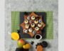 Mango sushi rolls arranged like a caterpillar with nori eyes for Halloween