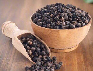 Whole black peppercorns beside ground black pepper