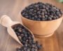 Whole black peppercorns beside ground black pepper